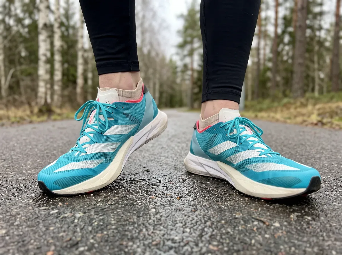 Adidas Adizero Adios 8 på fötterna på blöt asfalt